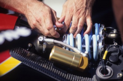 Mechanic operating on race car engine